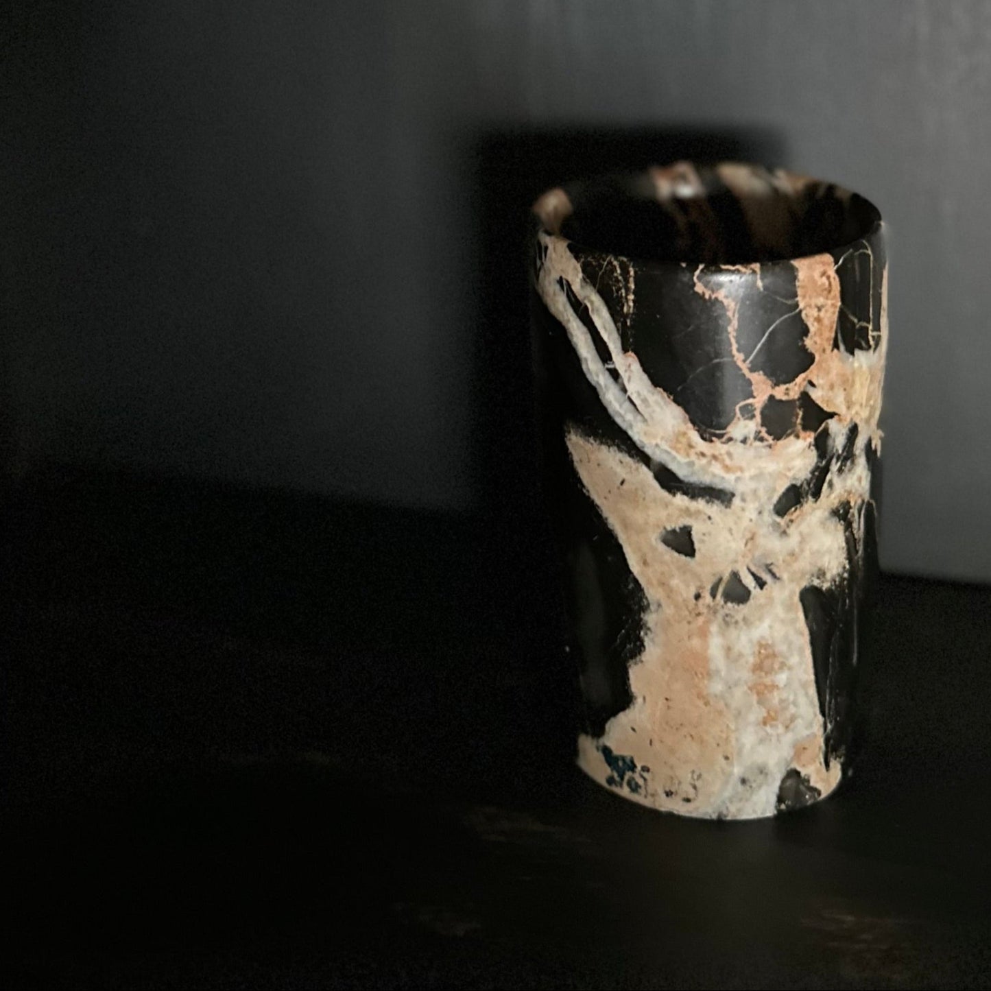 marble cup with black and white design on a dark background
