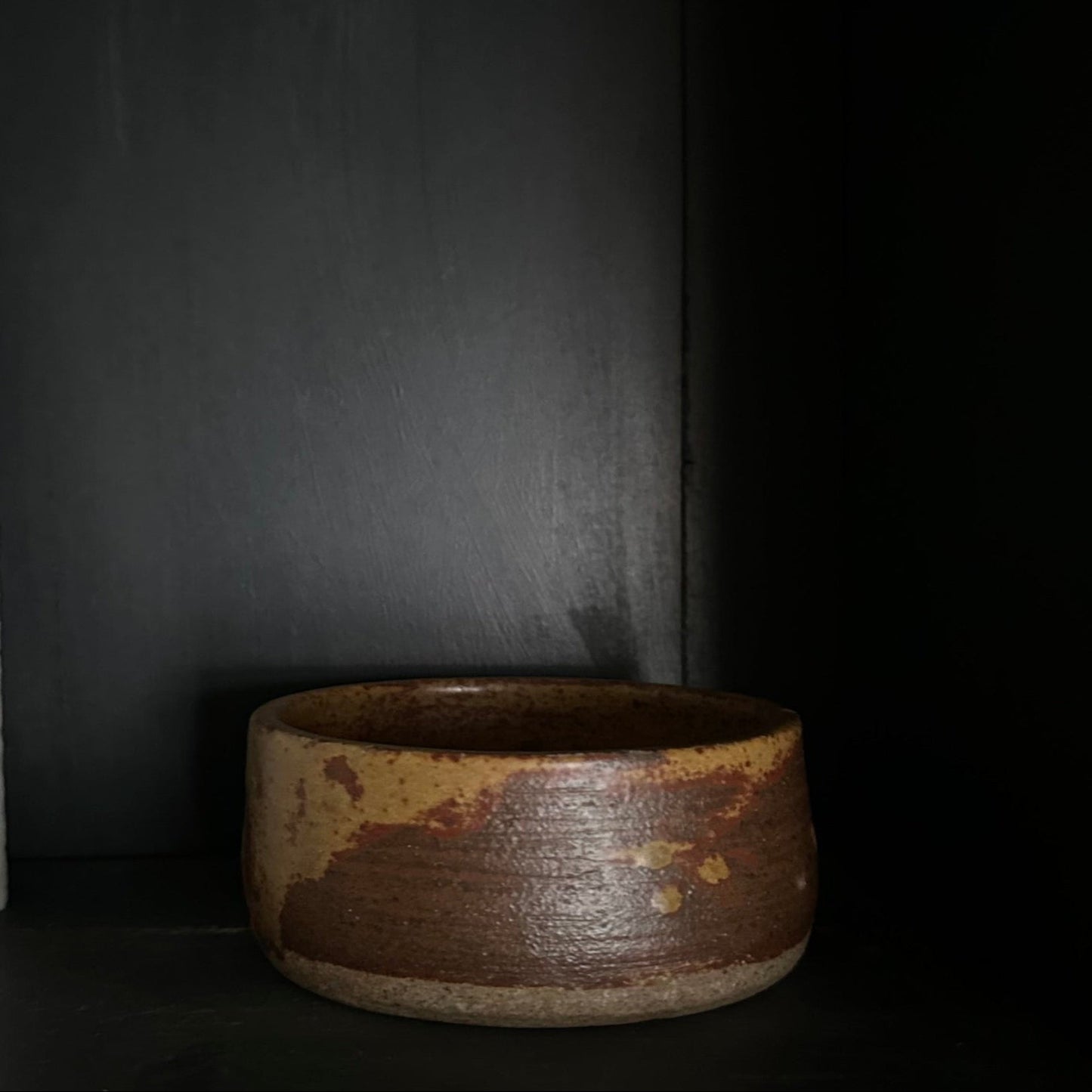 Brown ceramic bowl on a dark background